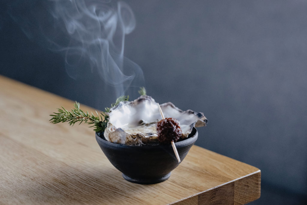 Juniper smoked oyster with goat sausage at culinary retreat at Holmen Lofoten Hotel